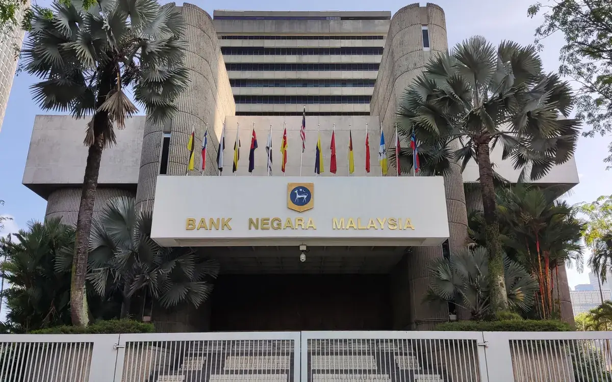 Вход в штаб-квартиру Bank Negara Malaysia в Куала-Лумпуре с флагами и пальмами