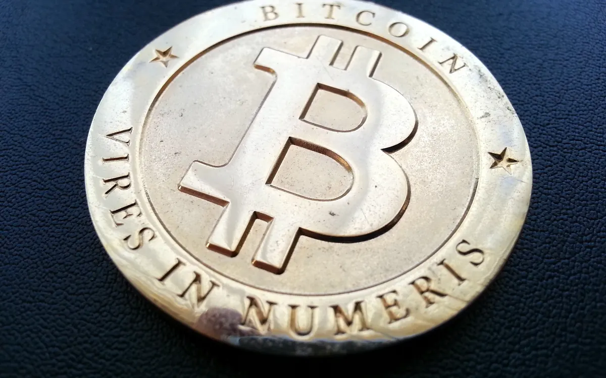 Close-up of a silver physical bitcoin coin with the motto Vires in Numeris (illustrative photo)