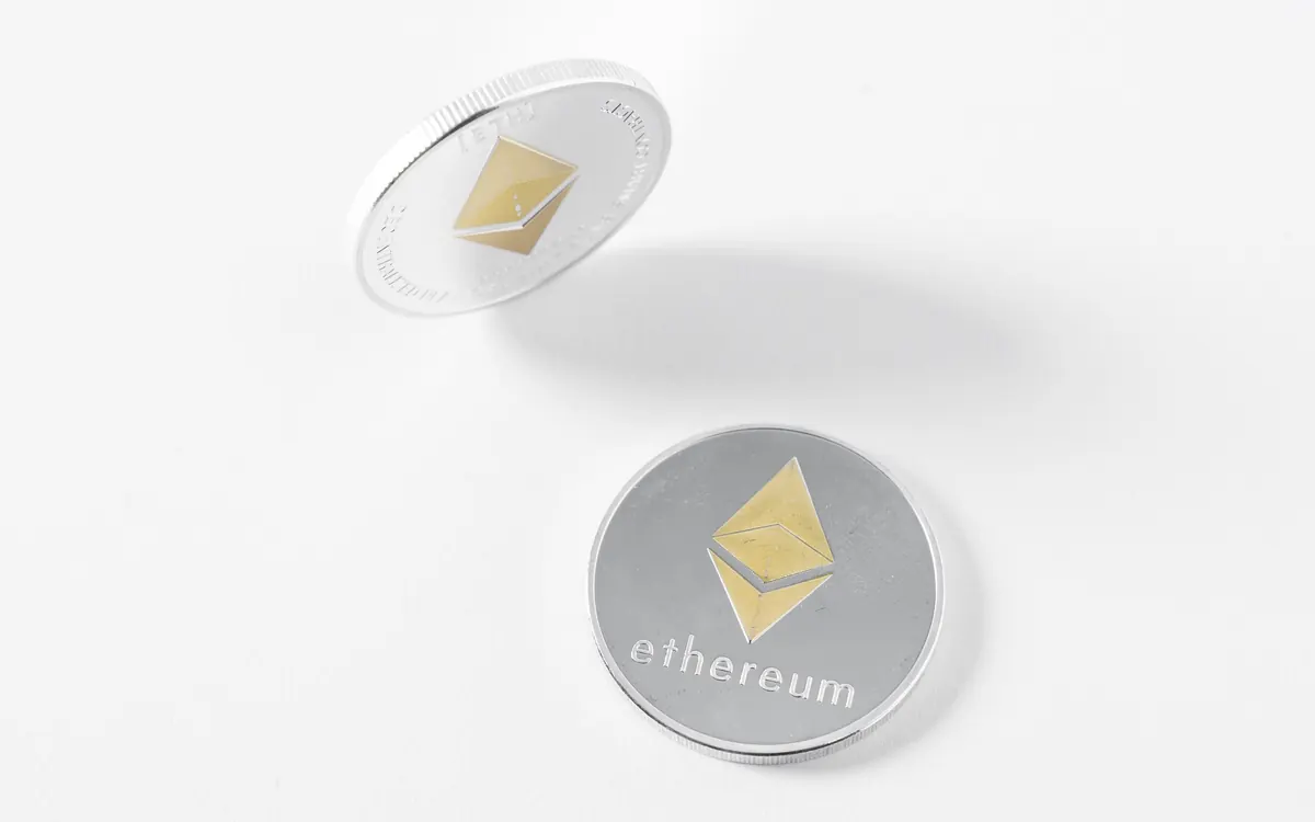 Two silver physical Ethereum coins on a white surface (illustrative photo)