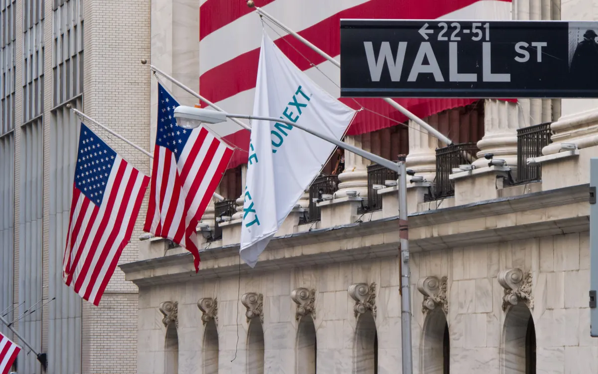 Wall Street street sign and US flags outside the New York Stock Exchange (illustrative photo)