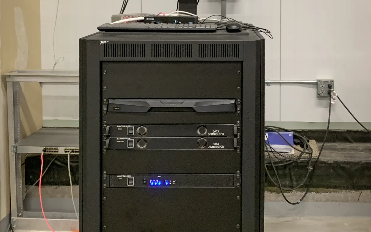A server rack with network equipment and a monitor on top in a utility room (illustrative photo)