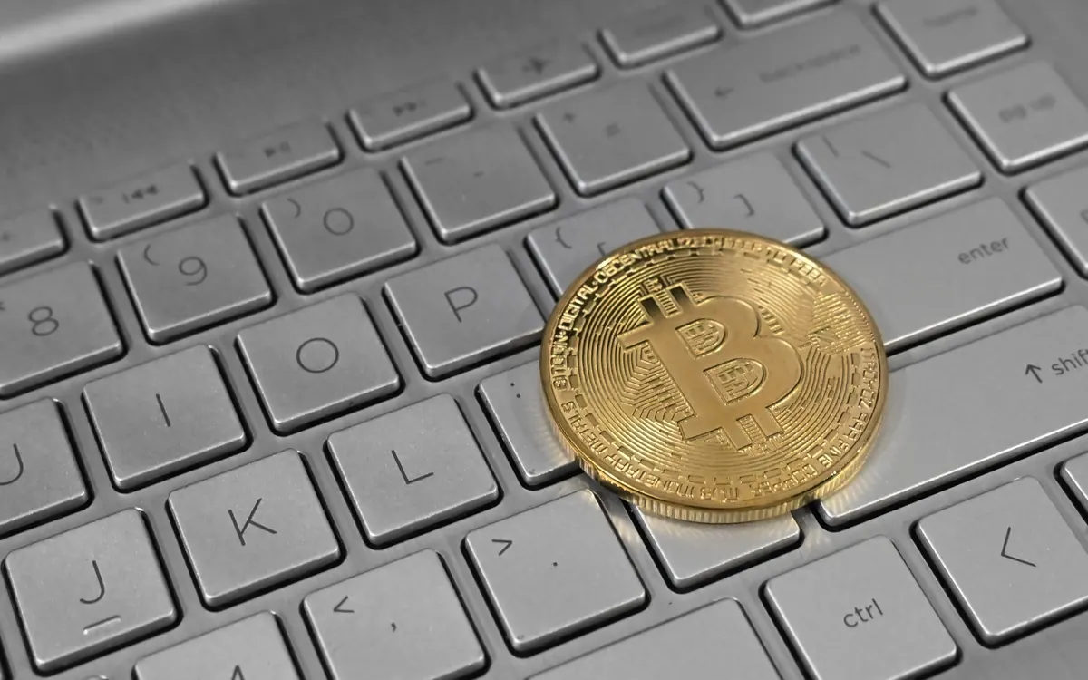 A bitcoin coin on a laptop keyboard (illustrative photo)