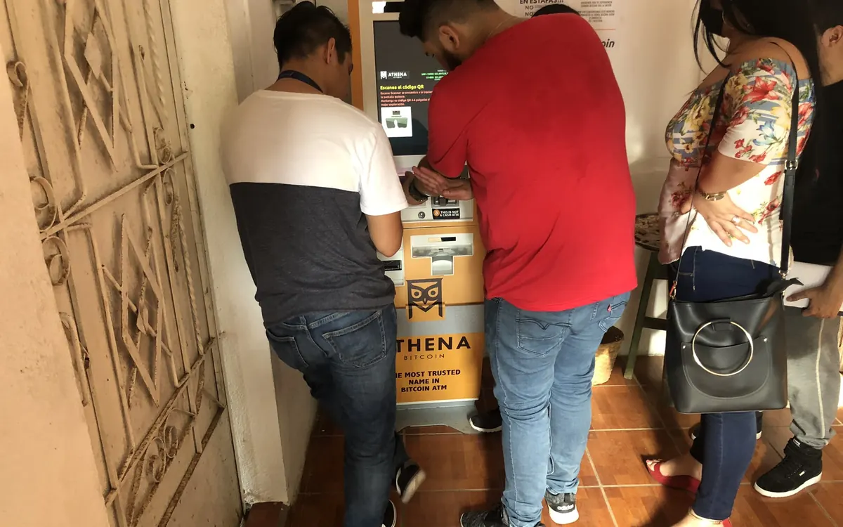 People using an Athena bitcoin ATM inside a building in El Salvador