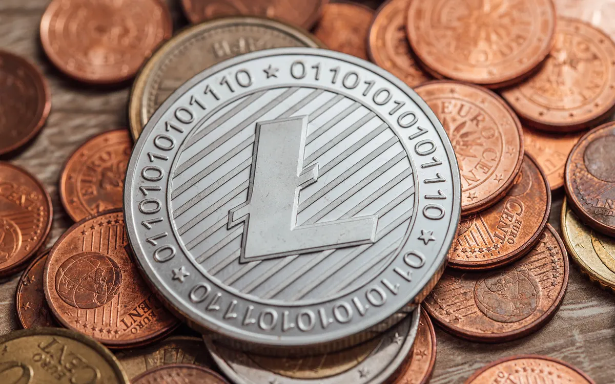 A physical altcoin (Litecoin) coin on a pile of coins (illustrative photo)