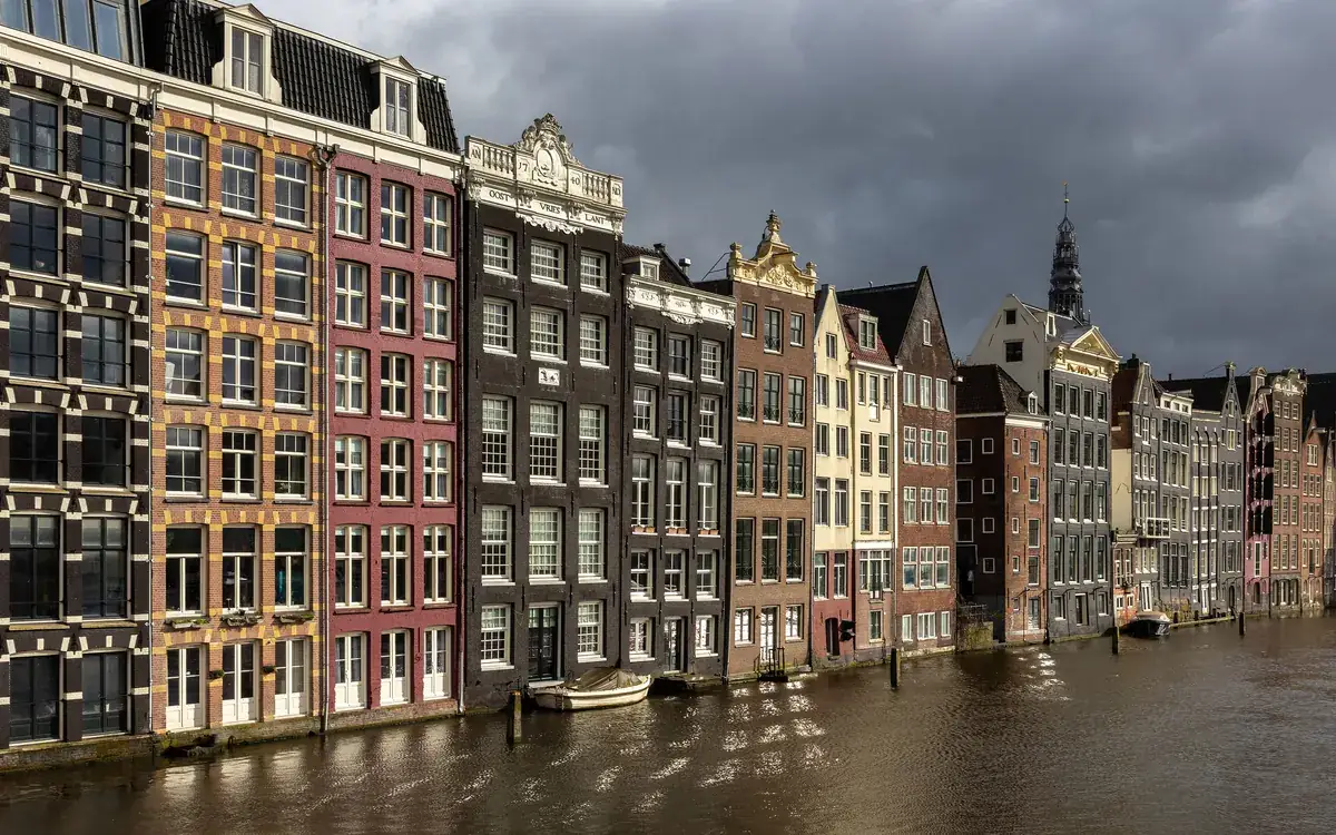 Colourful canal houses along the Damrak in Amsterdam, the city behind the name Glamsterdam (illustrative photo)