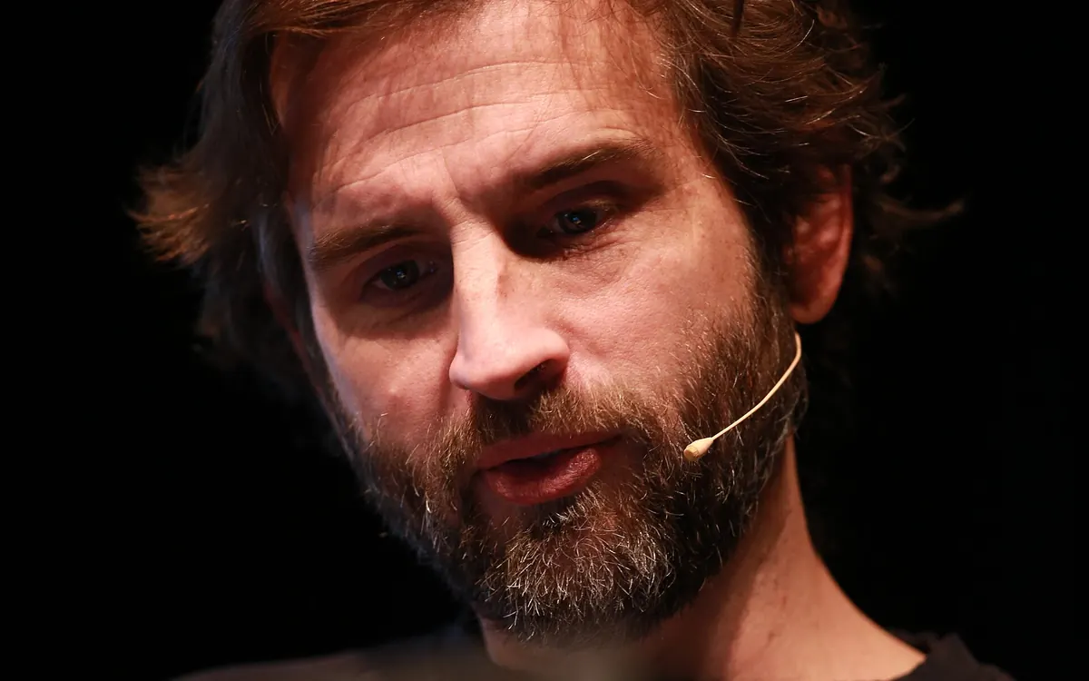 Zcash co-founder Zooko Wilcox-O'Hearn speaking on stage with a headset microphone (illustrative photo)