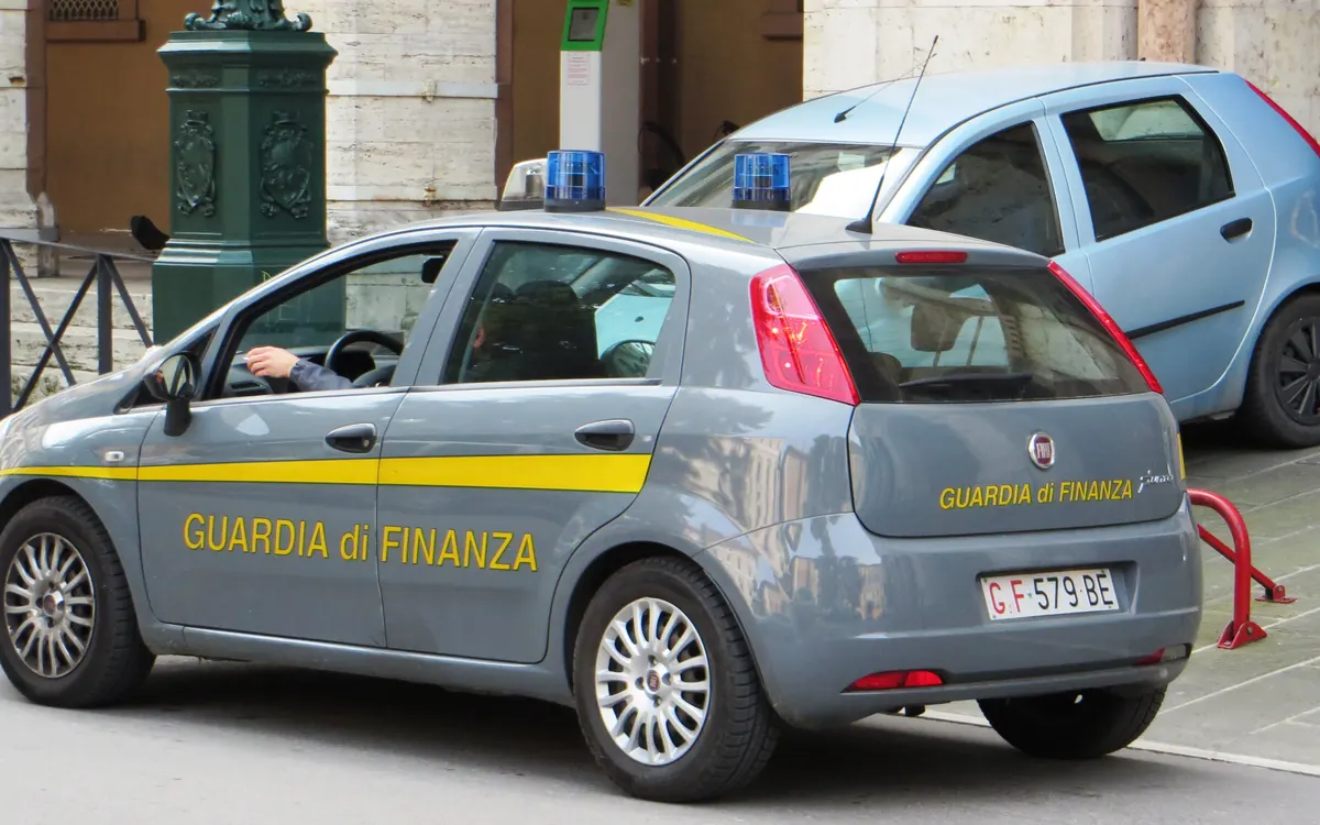A grey Guardia di Finanza patrol car with yellow stripes parked on an Italian street (illustrative photo)