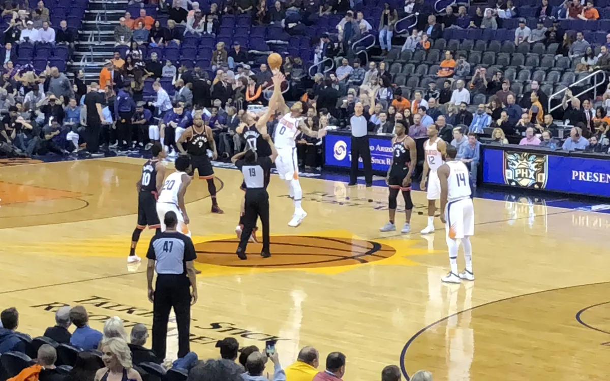 Tip-off of an NBA game between the Phoenix Suns and Toronto Raptors in a packed arena