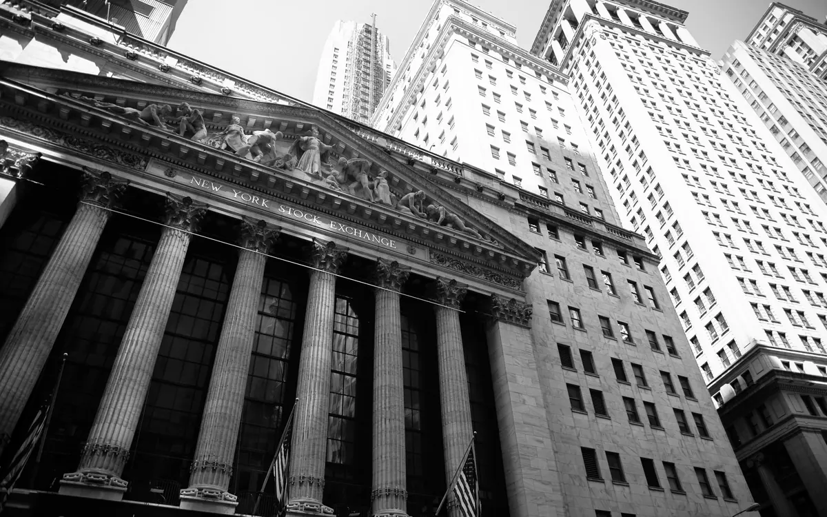 The columned facade of the New York Stock Exchange building on Wall Street, seen from below (illustrative photo)