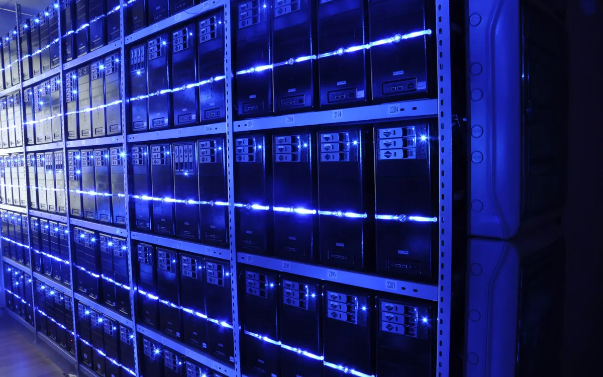 Rows of server racks in a data centre lit in green (illustrative photo)