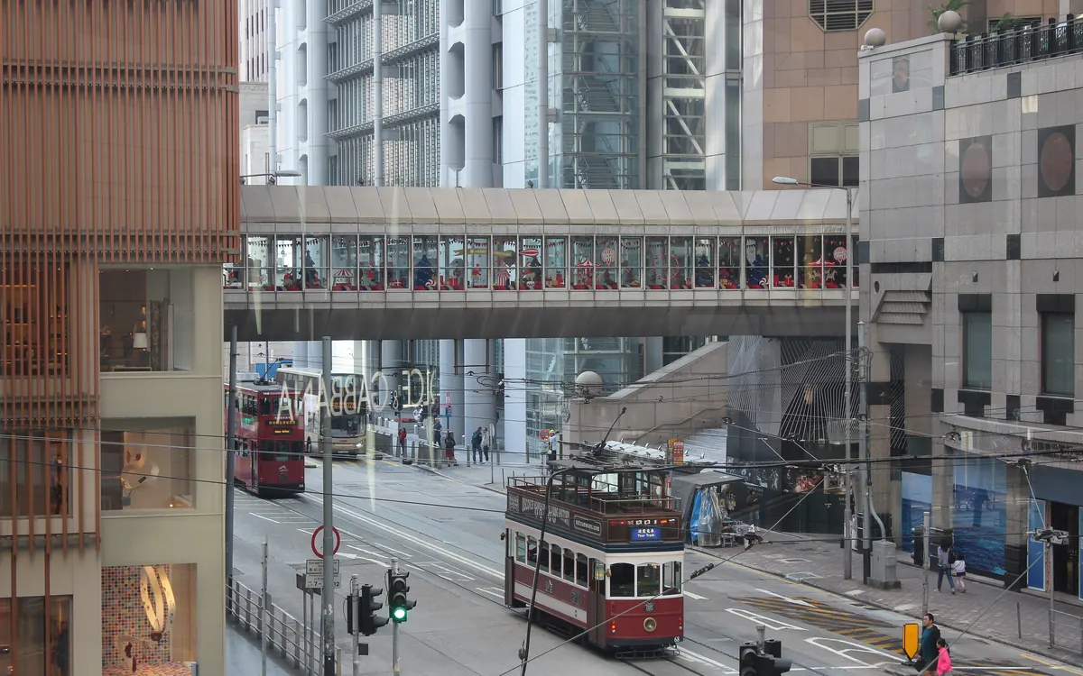 Footbridge linking the Standard Chartered Bank Building and Prince's Building above a tram in Central, Hong Kong (illustrative photo)