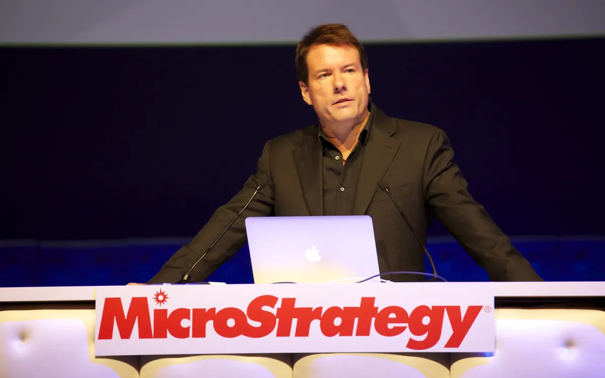 Майкл Сэйлор, исполнительный председатель Strategy (бывшая MicroStrategy), выступает за трибуной с надписью MicroStrategy