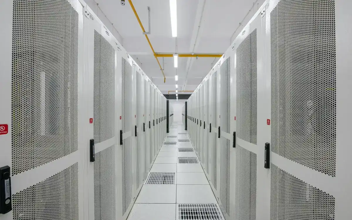 A long aisle of server cabinets in a data centre, where many Ethereum validators are hosted (illustrative photo)