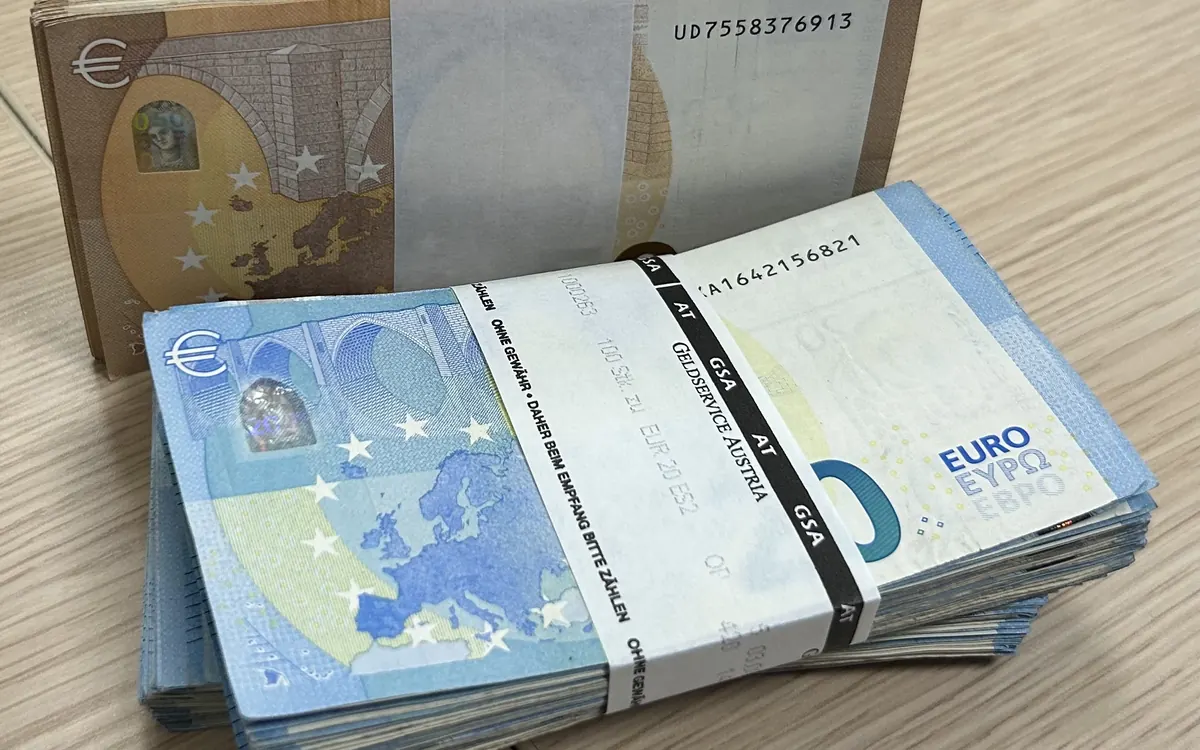 Strapped bundles of 20 and 50 euro banknotes on a table (illustrative photo)