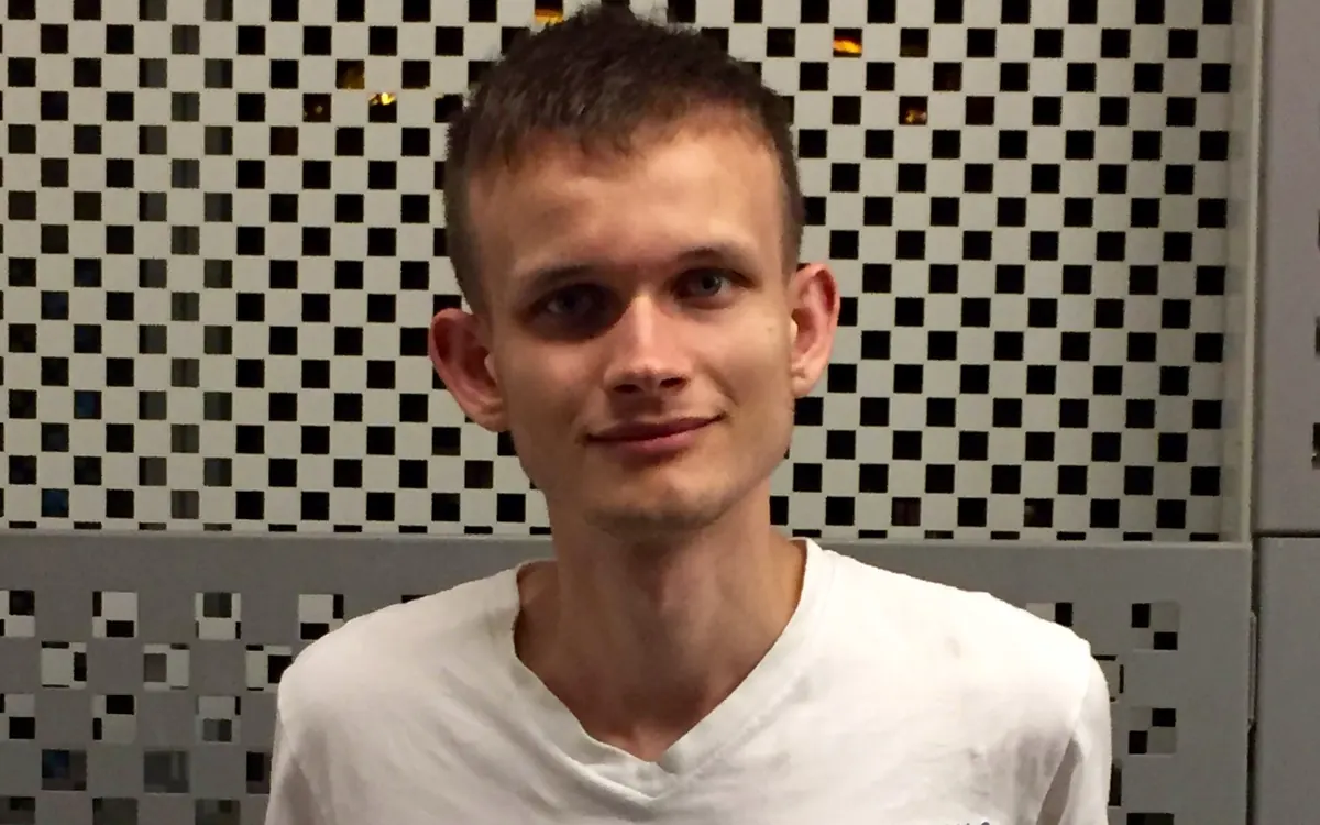 Ethereum co-founder Vitalik Buterin in a white T-shirt in front of a perforated wall