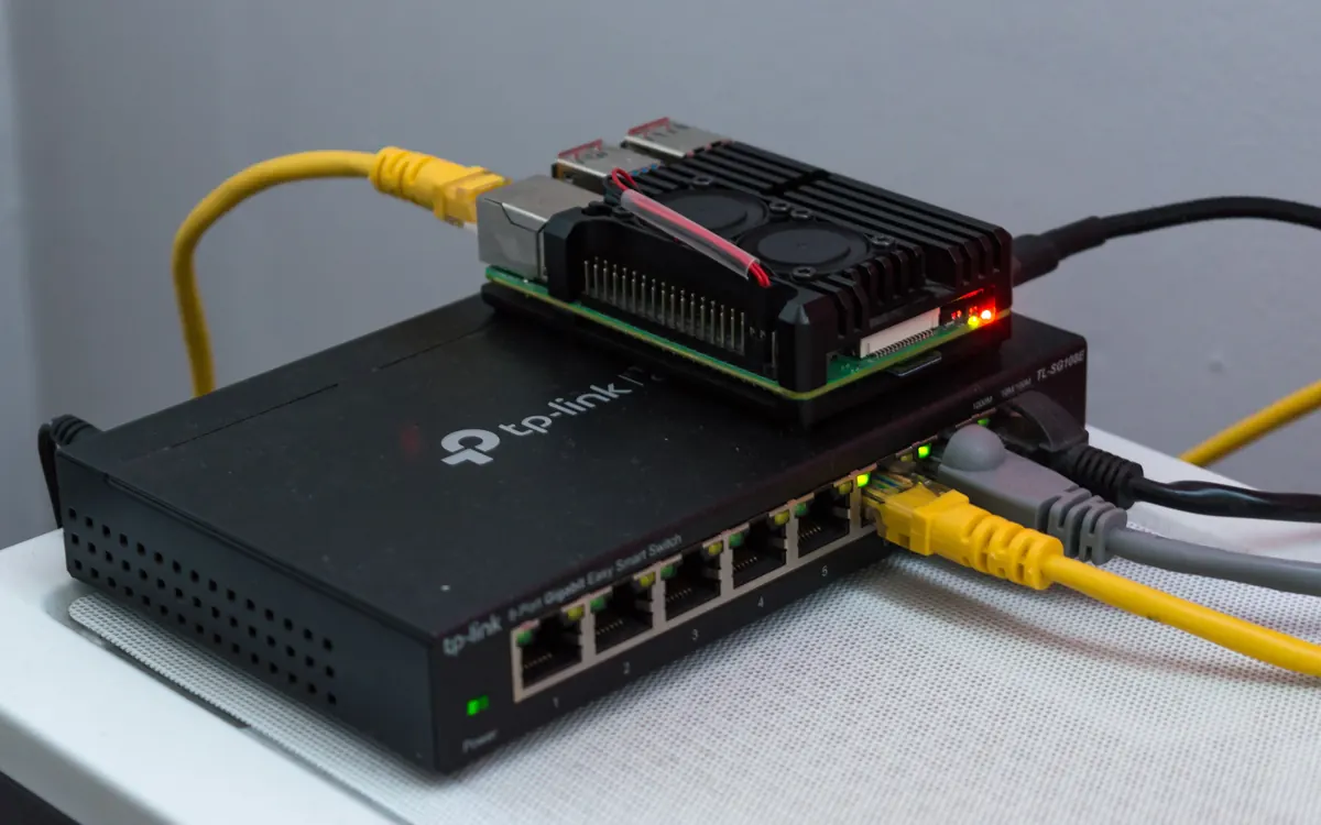 A Raspberry Pi single-board computer sitting on a network switch with Ethernet cables, a common home bitcoin node setup (illustrative photo)