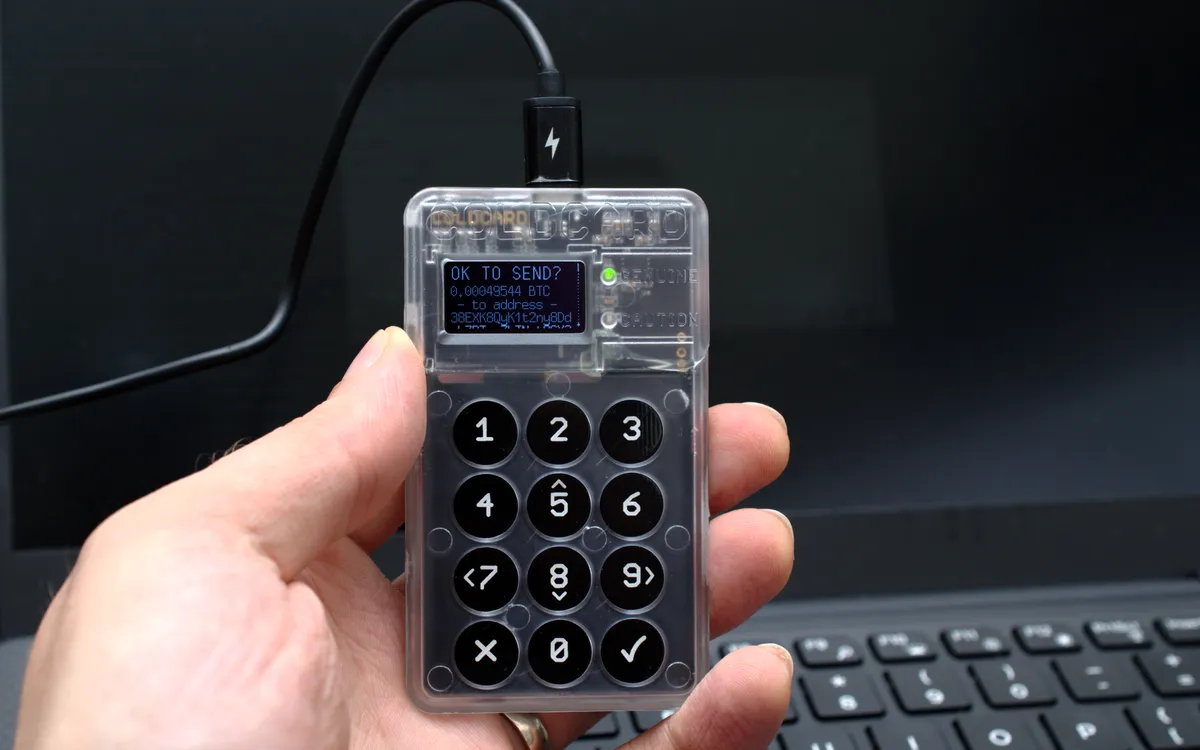 A hand holding a Coldcard hardware wallet that is asking to confirm a bitcoin transaction (illustrative photo)