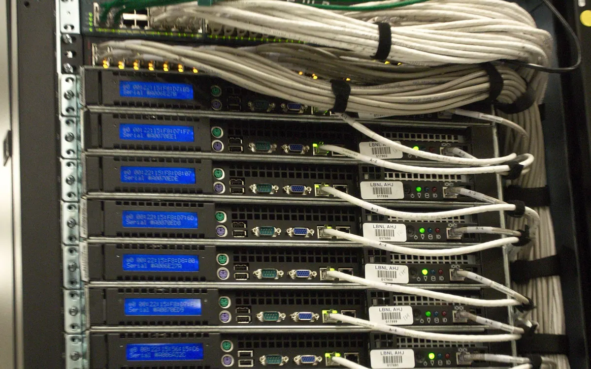 Rack of networked servers with blue status screens in a data centre, the kind of hardware validators run on (illustrative photo)