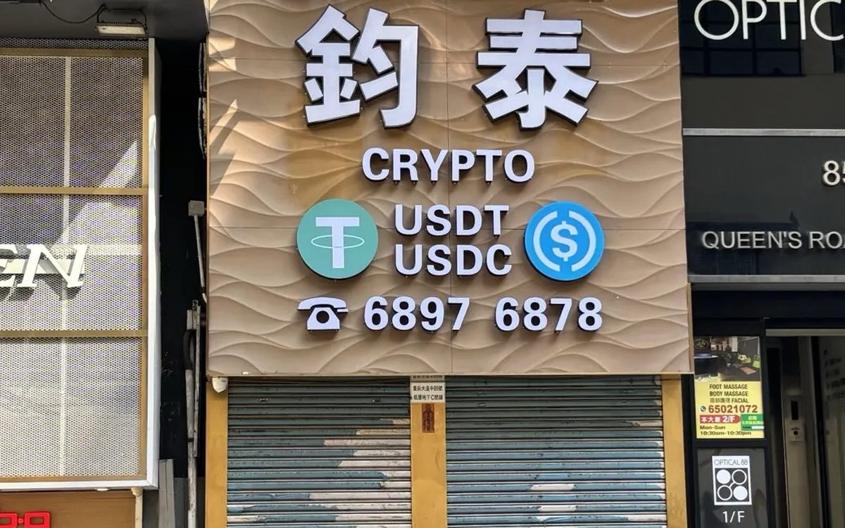 Shopfront of an over-the-counter crypto exchange in Asia with Tether USDT and USDC logos on its sign